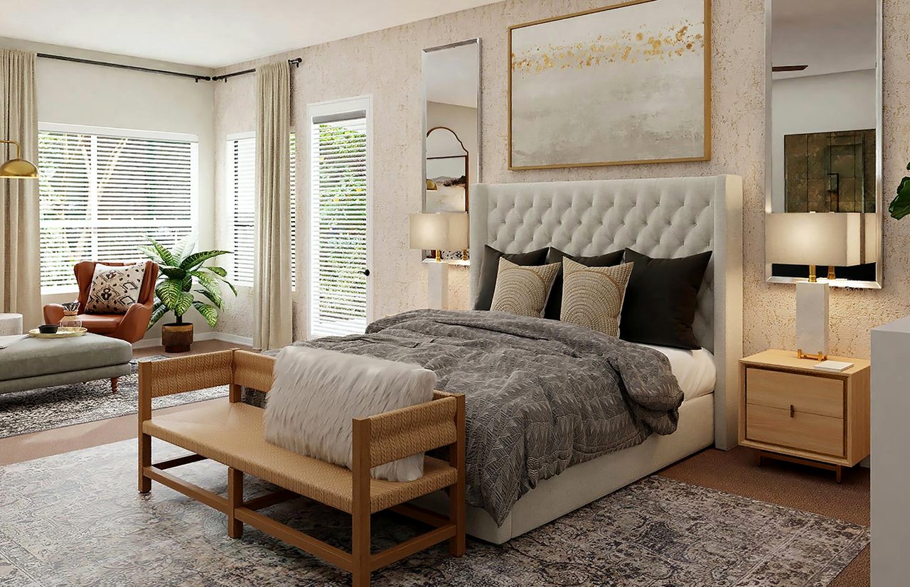 A front room with bay windows, a wicker bench and a large framed picture above the bed